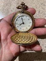 Front view of the Geneva pocket watch open to show white dial with black Arabic numerals and black hands. Marked Geneva and Anti Magnetic.