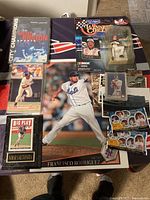 View of collection including framed baseball cards like Nomar Garciaparra Big Play card, large poster of Francisco Rodriguez, boxed NASCAR collectible, football cards and playing cards.