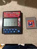 Handheld Draw Poker electronic game device and Wordtris Gameboy cartridge shown front side, showing screen, buttons and cartridge label.