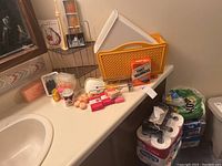 Full view of items on bathroom countertop including corner shelf, magazine holder, soaps, mirrors, and toilet paper