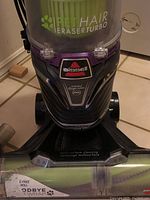 Close up photo of the Bissell Pet Hair Eraser Turbo Plus upright vacuum showing clear dust compartment and brush roll area.