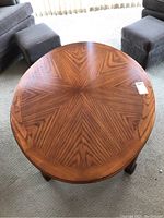 Top view of oval coffee table showing wood veneer surface with starburst grain pattern.
