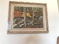 Frontal view of framed oil on board landscape painting depicting woodland stream and trees with autumn foliage.