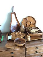Photo showing full assortment of wooden trays, bowls, and utensils arranged on furniture.
