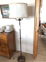Full view of the full height 63 inch vintage floor lamp with fabric shade and brass base.