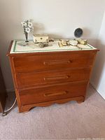 Front view of solid wood dresser with three horizontal dovetail drawers and aged wear.