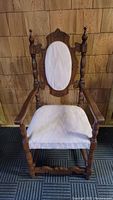 Front view of the 19th Century Jacobean style armchair showing carved wooden frame, oval upholstered backrest, and cushioned seat.
