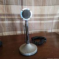 Full view of vintage Astatic D104 microphone on weighted base stand with coiled cable attached.