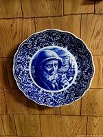 Front view of blue and white sea captain charger plate with ornate floral border.