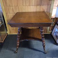 Front angle showing the oak parlour table with spiral carved legs and a lower shelf.