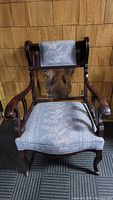 Frontal view of the Victorian mahogany armchair showing the carved wooden frame and upholstered seat and backrest.