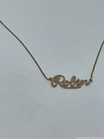 Close-up of the necklace focusing on the 'Robin' pendant with diamond dot on the 'i'