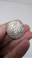 Reverse side of 1962 Canadian 50 cent coin showing Canadian coat of arms and denomination.