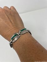 Bracelet worn on wrist showcasing the green inlay design and link structure.
