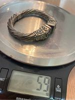 Silver rope-style bracelet on digital scale showing weight as 59 grams.