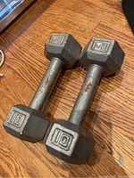 Pair of metal dumbbells with hexagonal weights and visible wear.