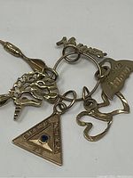 All five charms on a gold jump ring displayed on white background