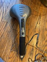 Front view of the Home Medics massager showing the brand label, adjustable speed slider, and ergonomic handle.