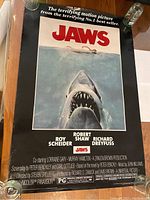 Full front view of the Jaws movie poster showing the shark and swimmer image with title and credits.
