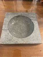 Top view of square grey marble ashtray showing central dome and two shallow indentions