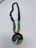 Full view of the necklace with the Murano glass circular pendant showing the bead strand.