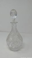 Full view of vintage crystal decanter with stopper, showing the elegant teardrop-shaped body with etched decoration.