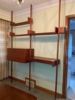 Full front view of assembled bookcase system showing shelves, desk module and drawer