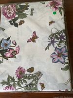 Folded tablecloth in package showing floral, butterfly and bee design