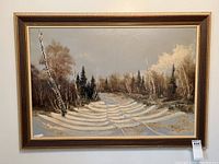 Framed oil painting showing entire snowy landscape scene with birch trees, pine trees, and a snow-covered path under a cloudy sky.