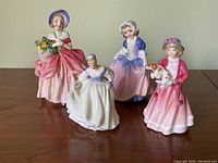 Front view showing all four figurines (Cissie, Dinky Do, Fair Lady, My First Figurine).