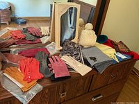 Overview of all gloves and scarves arranged on table showing variety of styles and colors.