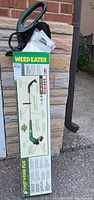 Photo of Weed Eater edge trimmer box leaning against a wall, showing product branding and specifications.