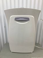 Front view of 3M Filtrete air purifier showing the off-white body and gray handle on front panel.