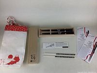 Overview of chopsticks, packaging bag, wooden box and instruction cards laid out on table