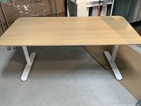 Front elevation showing full desk width and two T-shaped legs.