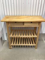 Front view of the IKEA Forhoja wooden kitchen cart showing top, drawers, and shelves