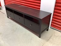 Full view of the IKEA Hemnes TV stand showing the three drawers and three open compartments, dark wood finish.