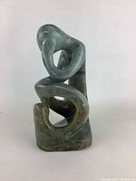 Back view showing full shape and polished green marble surface with minor chips and marks visible.