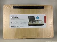 Photo of the boxed lap desk showing the packaging top with product identification label and original shrink wrap intact.