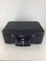Front view of locked black SentrySafe chest with handle and attached keys.
