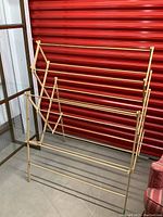 Full front and side view of the wooden drying rack showing multiple horizontal rods and folding mechanism.