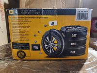 Box front showing product image, features, and fit specifications for the CAT 4-piece tire covers with handles.