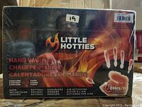Front of Little Hotties hand warmers box showing brand logo, flame and hand image, and key features.