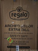 Cardboard packaging box for the Regalo Arched Decor Extra Tall Safety Gate in bronze, showing model number 0380 BR DS and dimensions fitting openings 29-35" wide by 36" high.