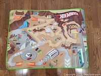 Full view of the Hot Wheels design play mat showing colorful desert terrain with river, cars, and racing tracks.
