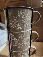Closeup stacked view highlighting the floral pattern and handle details of the mugs