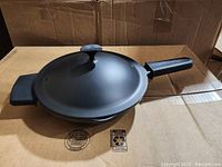 Photo showing the Curtis Stone cast aluminum pan with attached handle and lid with knob top.