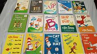 Photo showing 15 Dr. Seuss children’s books arranged in a grid on a white surface, with colorful illustrated covers visible and varying titles.
