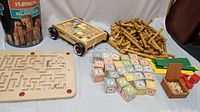 Overview of all wooden learning toys and vintage games including alphabet blocks, pull toy wagon, Lincoln Logs pile, maze game, and dice box.