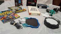 Photo showing various electronic gamer accessories including portals, character figure, magazines, and boxed items.